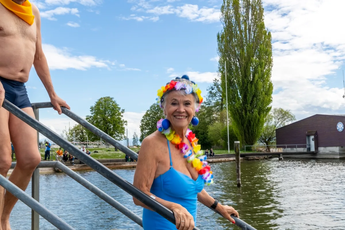 Eine Frau mit blauem Badeanzug und blauen Eierohrringen.